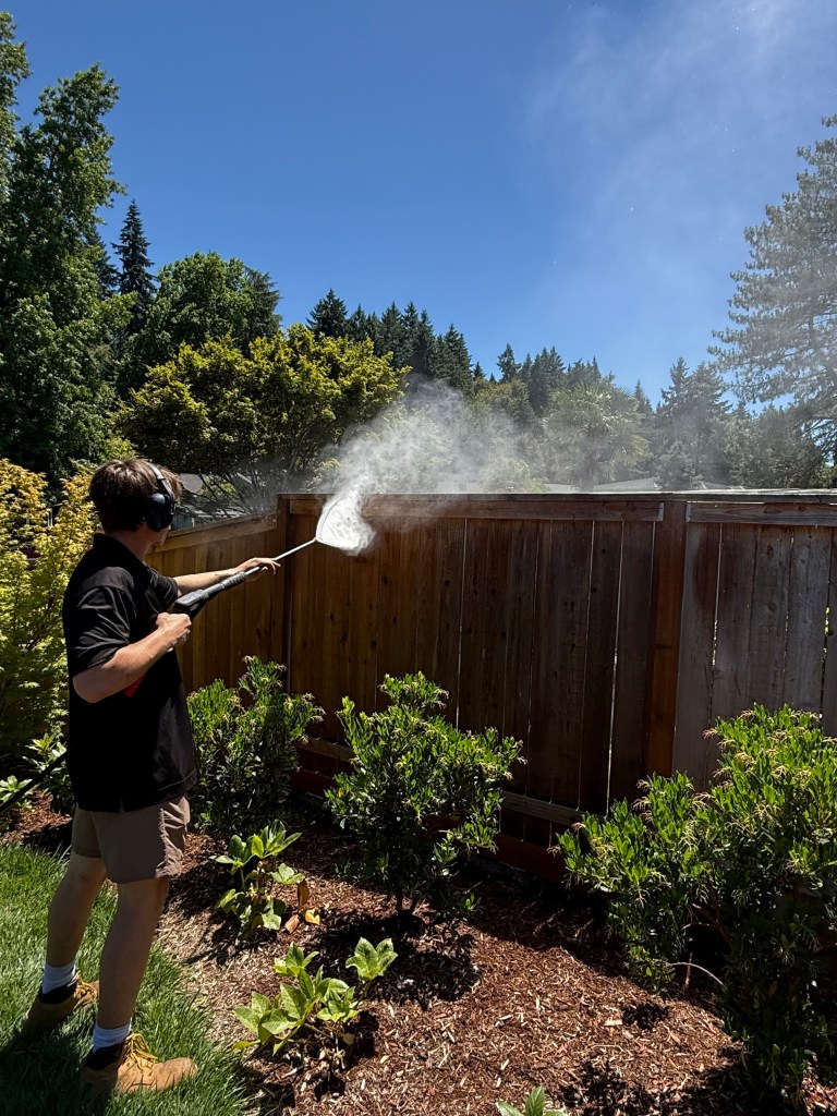 GreenTree Services pressure washing a wood privacy fence in Oregon
